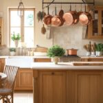 Stunning French Country kitchen featuring a farmhouse sink, wooden island, copper accents, and a cozy breakfast nook.